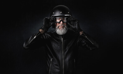 Portrait d'un motard biker homme vintage avec un casque noir et une veste en cuir 