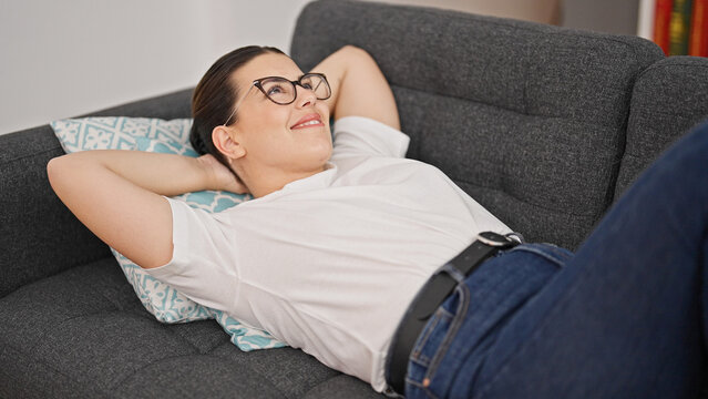 Young beautiful hispanic woman relaxed lying on sofa with hands over head at home