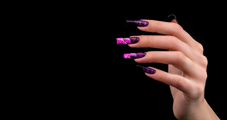 Hand with a beautiful manicure on a black background. Nail design. Extended nails.