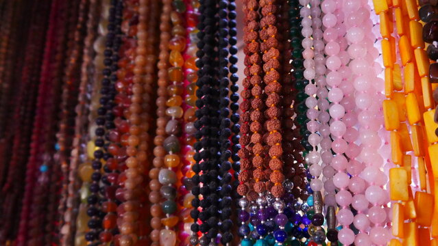 Gros colliers style artistique de l'inde, vente dans un stand, bijoux de religion et de croyance, objet de valeur, de toutes les couleurs, produit insoutenables touristique, représentation hindouisme