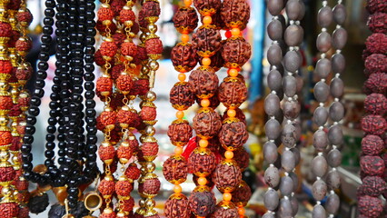 Gros colliers style artistique de l'inde, vente dans un stand, bijoux de religion et de croyance, objet de valeur, de toutes les couleurs, produit insoutenables touristique, représentation hindouisme