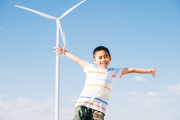 A portrait of a happy boy amidst a wind farm. Joyful family time in nature's embrace embracing...
