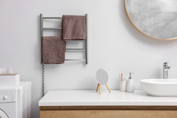Heated towel rail with brown towels in bathroom