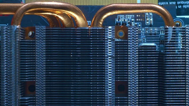 Powerful radiator with copper tubes for circulating coolant to cool the computer video card. Closeup. Macro