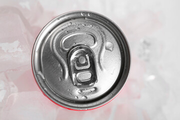 Energy drink in wet can and ice cubes on light background, top view