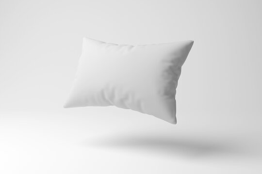 White pillow floating in mid air on white background in minimalism and monochrome. Illustration of the concept of sleep, sleeping quality and insomnia