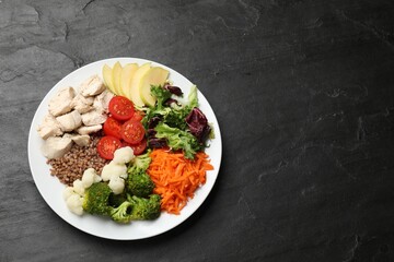 Balanced diet and healthy foods. Plate with different delicious products on black table, top view....