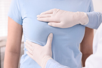 Mammologist checking woman's breast in hospital, closeup