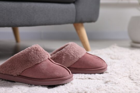 Pink soft slippers on carpet indoors, closeup. Space for text