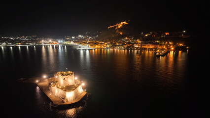 Aerial drone night shot of illuminated castle of Bourtzi built at sea a popular attraction in city...