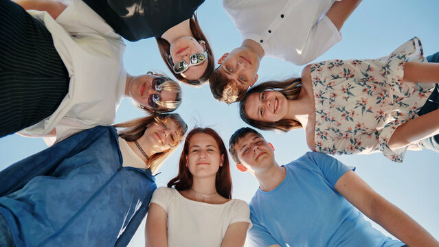 Friends put their heads together in a circle on a summer afternoon.