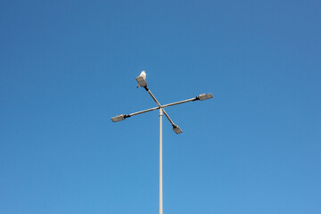 bird sitting on a pole against a blue sky