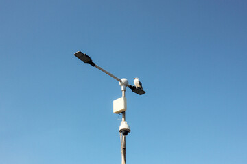 bird sitting on a pole against a blue sky