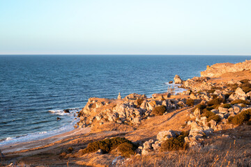 Seascape. Rocky Crimean seashore with a field road in the evening. Travel and tourism.