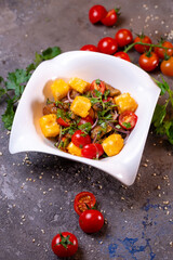 Grilled chicken cheese salad with tomatoes, onions and dill in a white bowl