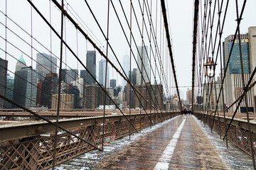 View of Manhattan from the Brooklyn Bridge during winter in a foggy day