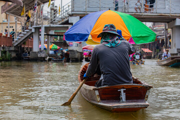 man rowing a boat on a city river Bangkok
