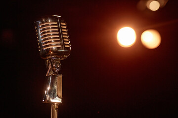 Close up of retro microphone on stage with spotlights in background copy space