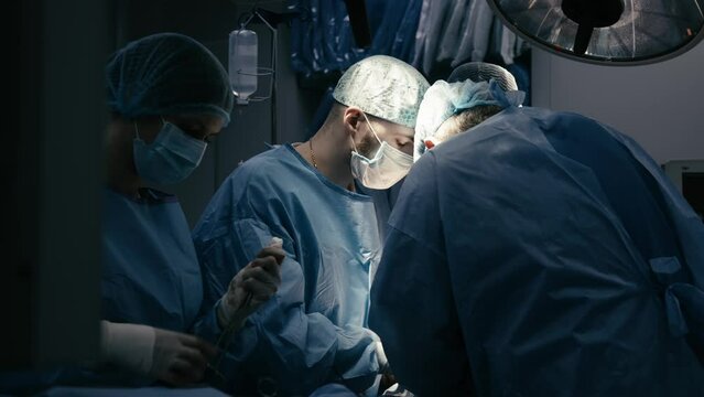 Multinational collaborative team of surgeons performing a surgical operation in the operating room of a modern hospital emergency department. Heart surgery.