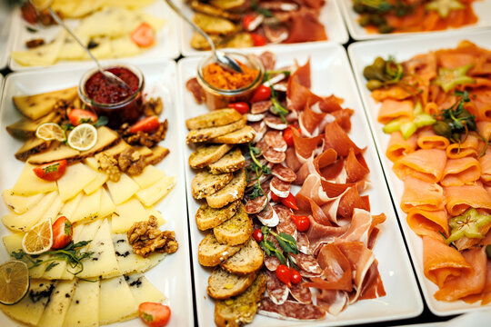 Spread of gourmet delicacies, featuring an assortment of finely sliced meats, artisanal cheeses.