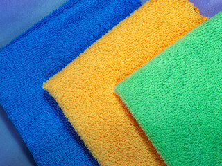 Microfiber cleaning towels. Universal microfiber cloth for cleaning objects and surfaces on a blue background. Cleaning cloth, napkin. Four folded towel.