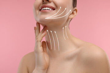Woman with perfect skin after cosmetic treatment on pink background, closeup. Lifting arrows on her...
