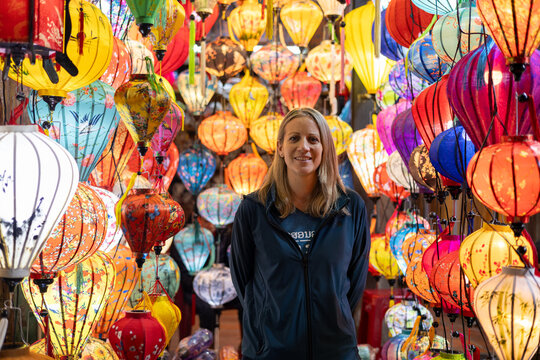 Happy Western tourist among Asian silk lanterns