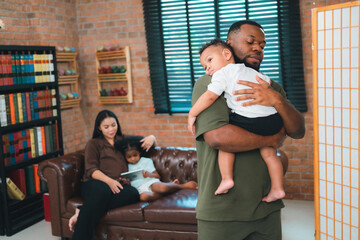 Smiling African-American father shares fun and love with his cheerful children at home, celebrating family with childhood together, African American black person in happy together of father's day - 765031642