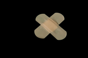 Skin coloured (for Caucasians) plasters on a black blackground.