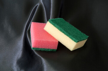 Scouring pads on a black satin background.
