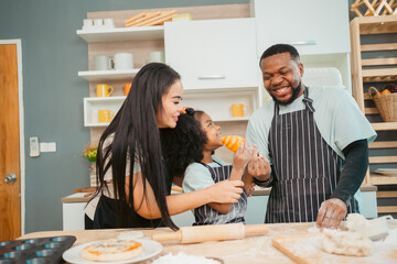 In a home kitchen, black father and his daughter bond over cooking a meal food, their laughter and love filling the air, embodying the joy of African American family life, Father's Day concept - 765031860