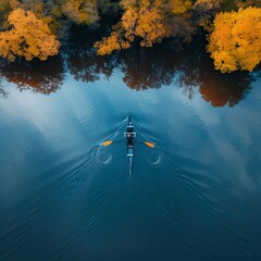 Person rowing on a calm lake in autumn, aerial view only small boat
