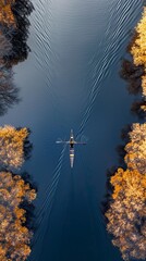 Person rowing on a calm lake in autumn, aerial view only small boat
