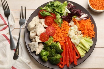 Balanced diet and healthy foods. Plate with different delicious products served on light wooden table, top view