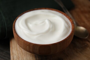 Obraz na płótnie Canvas Delicious natural yogurt in bowl and spoon on table, closeup