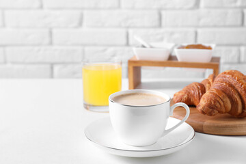 Breakfast time. Fresh croissants and coffee on white table. Space for text