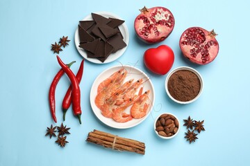 Natural aphrodisiac. Different products and heart model on light blue background, flat lay