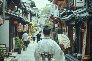 A woman wearing a white kimono walks down a narrow street in a foreign country