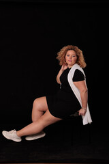 plus size blonde woman in photo studio on black background, curvy woman