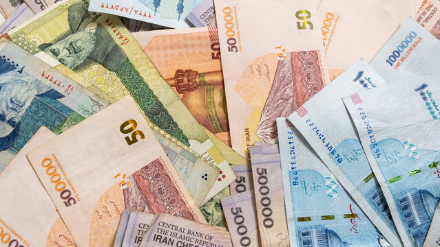Background from different Iranian Rial or IRR banknotes from Iran. Concept of economic crisis and save money