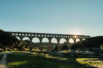 illuminated ancient Roman aqueduct Pont du Gard near Languedoc, France, built as part of the infrastructure for water supply of the roman empire. - obrazy, fototapety, plakaty