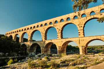 illuminated ancient Roman aqueduct Pont du Gard near Languedoc, France, built as part of the infrastructure for water supply of the roman empire.