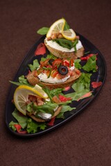 Bruschettas with cream cheese, tomatoes, olives, and lemon