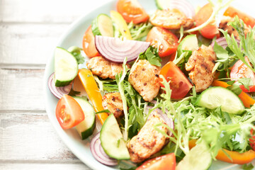 Healthy Salad with Chicken Breast, Cherry Tomatoes, Cucumber, Orange Pepper, Endive and Red Onion. Close up.	