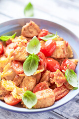 Farfalle pasta with chicken breast, cherry tomatoes and fresh basil. Bright wooden background. Close up.	