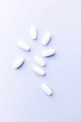 Amino acids tablets. Nutrition for bodybuilding. Fitness supplements on bright paper background. Soft focus. Copy space.	