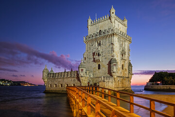 Belem Tower or Tower of St Vincent famous tourist landmark of Lisboa and tourism attraction on bank of Tagus River (Tejo) after sunset in dusk twilight with dramatic sky. Lisbon, Portugal - 765062815