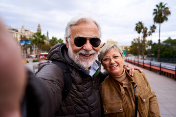 Happy Caucasian senior couple taking a selfie with their cell phone. Husband and wife smiling...