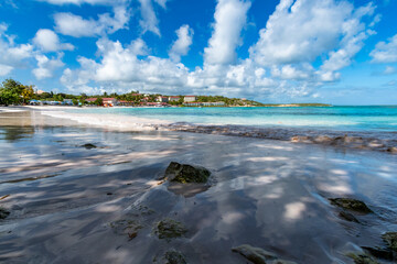 Rocks and Shadows on the sand of a tropical beach in the Caribbean with clear turquoise waters