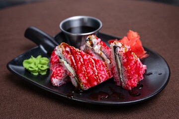 Closeup of a plate of sushi with chopsticks on a table